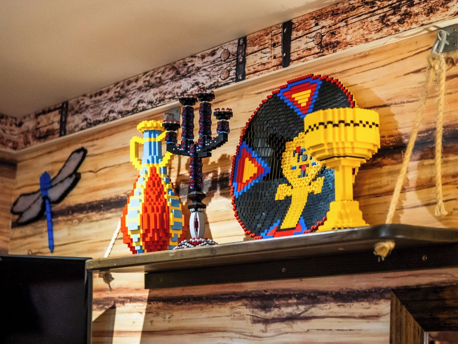 Una pared de madera con un estante que exhibe varios modelos LEGO.