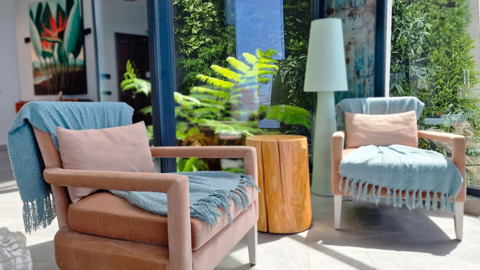 A modern outdoor seating area with two cushioned chairs and a small wooden table.