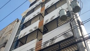 A multi-story building with a modern architectural design, featuring a mix of glass and metal elements.