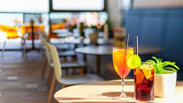 Een restaurantinterieur met ronde tafels, stoelen en een potplant.