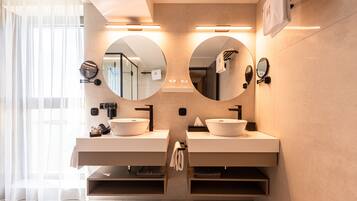 A modern bathroom with two sinks, large mirrors, and built-in shelves.
