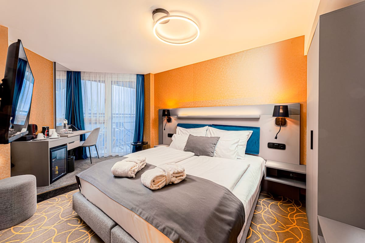 Ein Hotelzimmer mit einem Bett, einem Schreibtisch, einem Sessel und einem Fernseher.