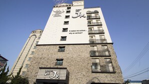 A tall building with a prominent 'Boutique Hotel' sign on the facade. - JK Hotel (Busan)