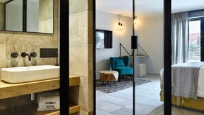 Ein modernes Badezimmer mit einem großen Spiegel, einem Waschbecken und einem Stuhl.