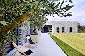 A modern building with stone walls and a well-maintained lawn. - DURBUY SUITES (Durbuy)