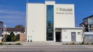 A modern building with a large sign reading "INhouse Wohnen auf Zeit". - INhouse Wohnen auf Zeit (Ingolstadt)