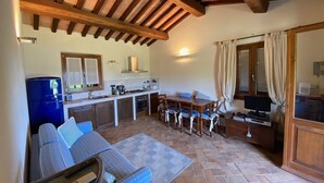 A compact kitchen with a dining area, a sofa, and a television. - Beautiful villa in the park of Elba Island (Redinoce)