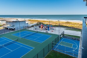 A tennis court with a view of the ocean. - Cute, cozy 2 bedroom oceanfront condo with free WiFi, a great ocean view, and awesome amenities including indoor/outdoor pools and a game room located uptown! (Ocean City)