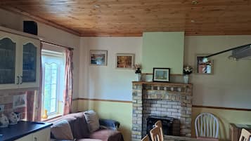 Una sala acogedora con chimenea, una mesa de comedor y un sofá.