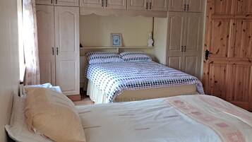 Une chambre à coucher avec un lit, une armoire et un radiateur.