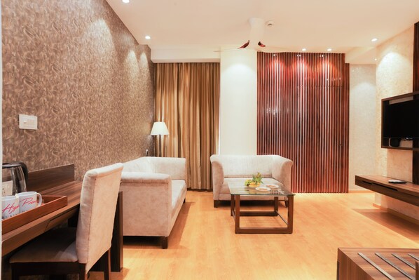 Una sala moderna con dos sofás, una mesita de centro, un televisor y una mesita auxiliar de madera.