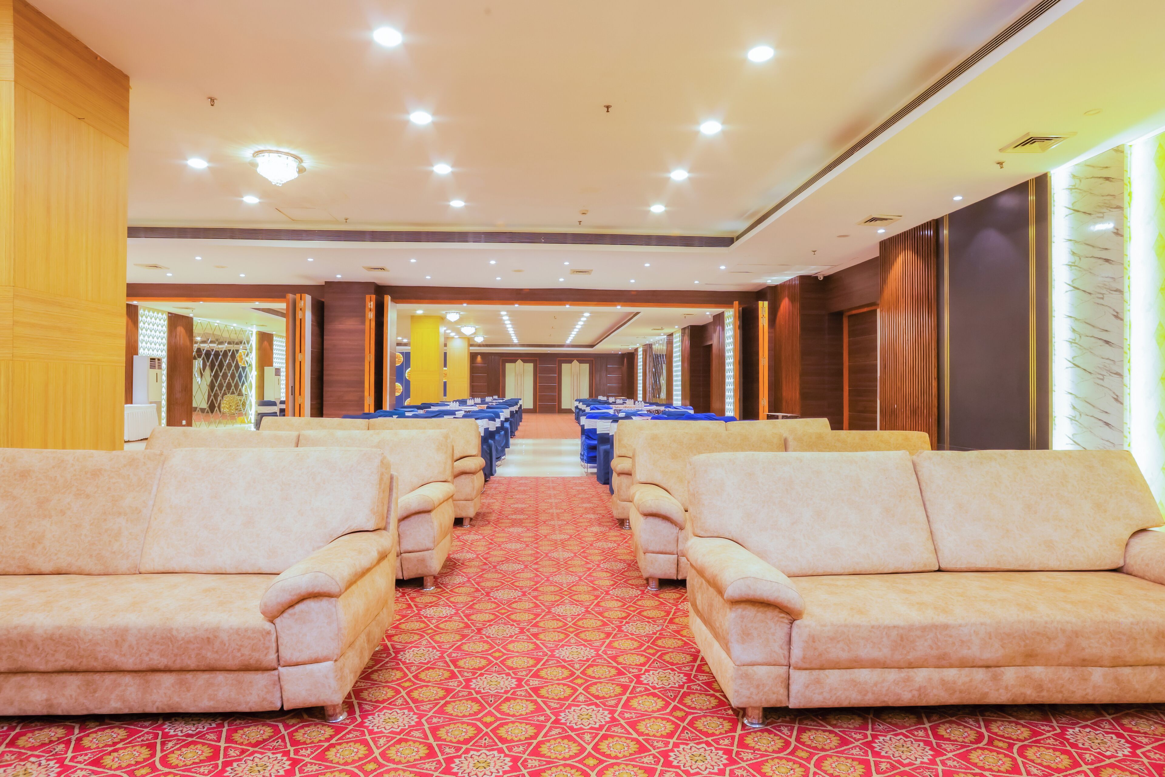 A hotel lobby with rows of sofas and a patterned carpet.