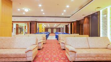 A hotel lobby with rows of sofas and a patterned carpet.
