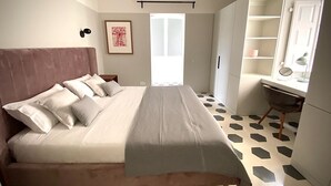 Een slaapkamer met een groot bed, een bureau en een stoel. Er is een raam met uitzicht op het omliggende landschap.