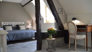 A bedroom with a bed, a desk, a chair, a vase with flowers, and a window. - La maison de Triboulet, bed and breakfast, Nutrisco, Nutrisco (Pocé-sur-Cisse)