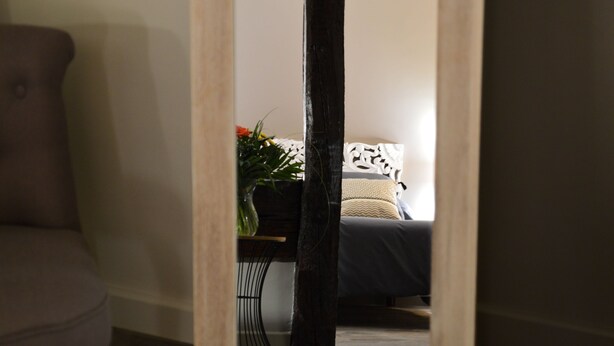 A bedroom with a bed, a nightstand, a vase with flowers, and a chair. - La maison de Triboulet, bed and breakfast, Nutrisco, Nutrisco (Pocé-sur-Cisse)