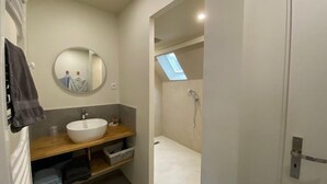 A modern bathroom with a round mirror, a sink, and a shower. - La maison de Triboulet, bed and breakfast, Nutrisco, Nutrisco (Pocé-sur-Cisse)
