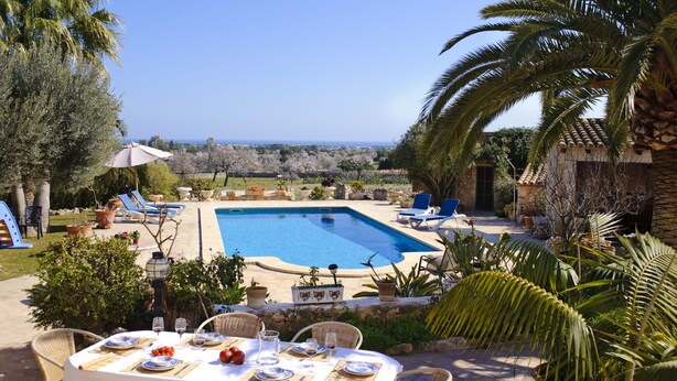 A pool area with lounge chairs and a table set for dining, overlooking a scenic landscape. - Tanca - Typical Finca with Private Pool, Sleeps 8, A/C, Wi-Fi, Near Cala d'Or (Santanyí)