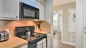 Una cocina con microondas, estufa y tostadora. Un letrero de neón sobre el microondas dice 'RnR Galveston'.
