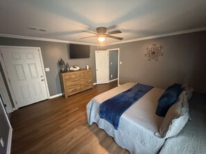 A bedroom with a bed, dresser, ceiling fan, and a door. - Cozy 4 bedroom House 2.5 bath (Albany)