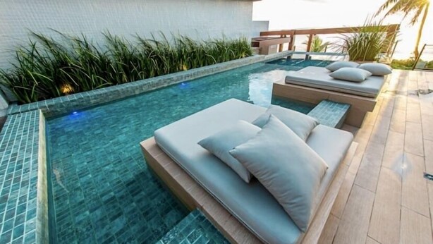 Una piscina al aire libre, sillones reclinables de piscina
