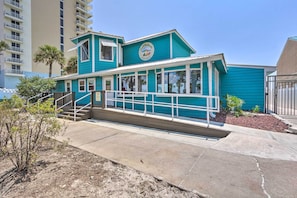 Um edifício turquesa com uma placa que diz 'Coco Beach Resort'.