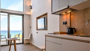 Una cocina moderna con un amplio ventanal, una cafetera y vistas al océano.