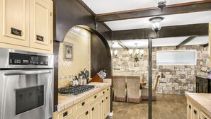A kitchen with a built-in oven, a stove, and a stone backsplash. - 316MAR - Modern Avalon house, AC, WIFI, Golf Cart and patio with BBQ (Avalon)