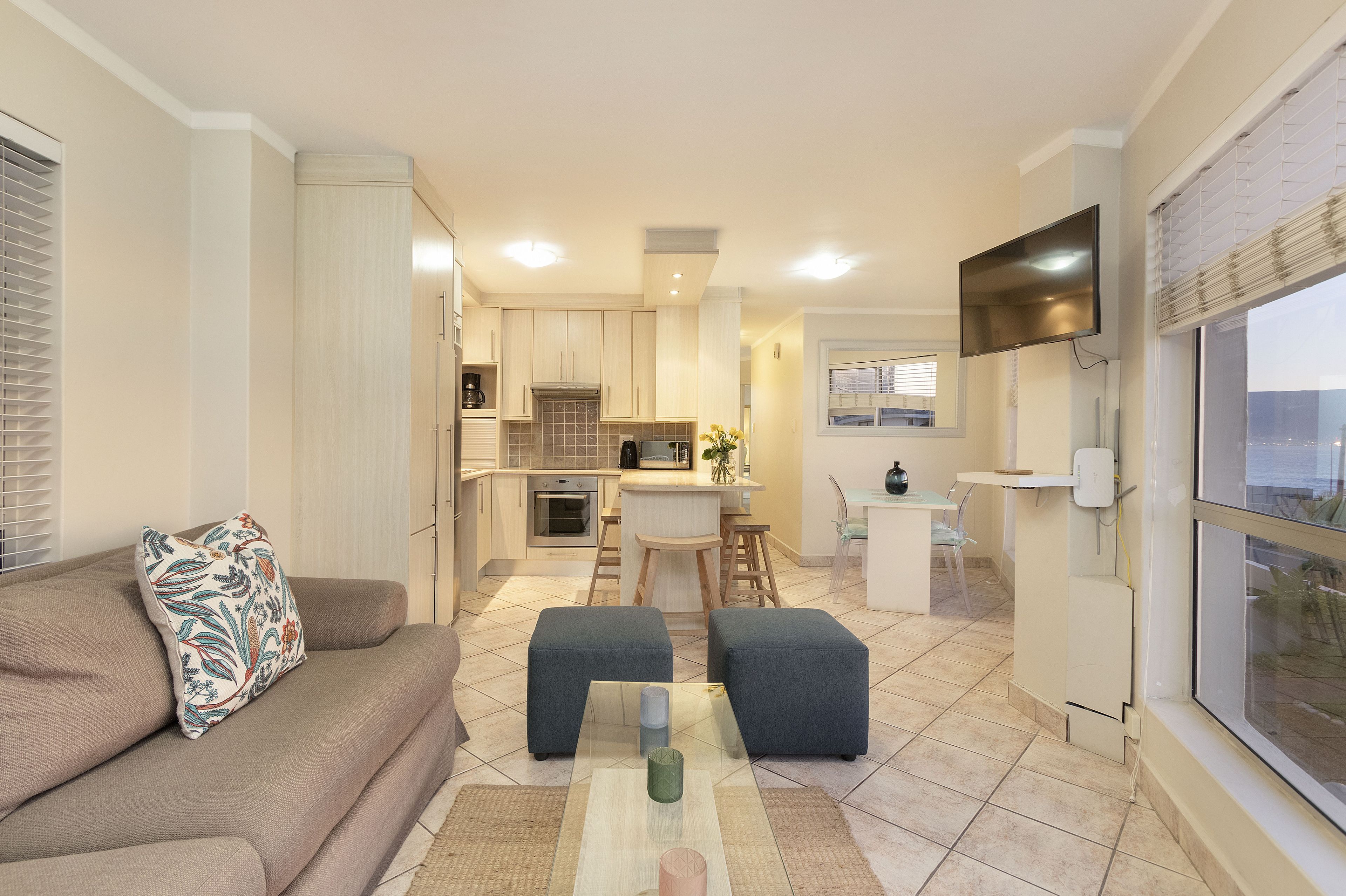 A modern apartment with a living room, kitchenette, and dining area.