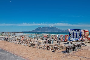 Un marché installé au bord de la plage, avec différents stands vendant de la poterie et des textiles.