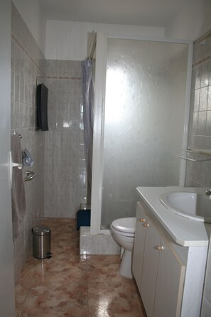 Un baño con ducha, inodoro y lavamanos.