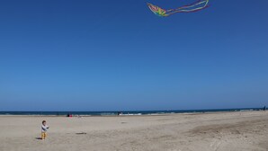 A beach with a child flying a kite. - Villa close to the beach with exceptional views. (Port-la-Nouvelle)