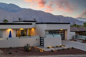 A modern two-story house with a garage, a covered patio, and a desert landscape with mountains in the background. - Stay in 3rd Rock Home ! (Palm Springs)