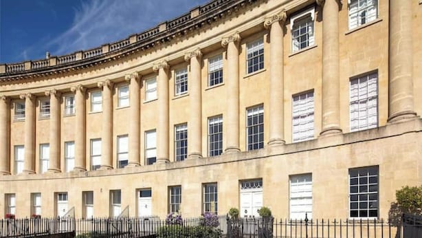 Un bâtiment de style classique, doté d’une façade symétrique, de grandes fenêtres et d’une entrée centrale.
