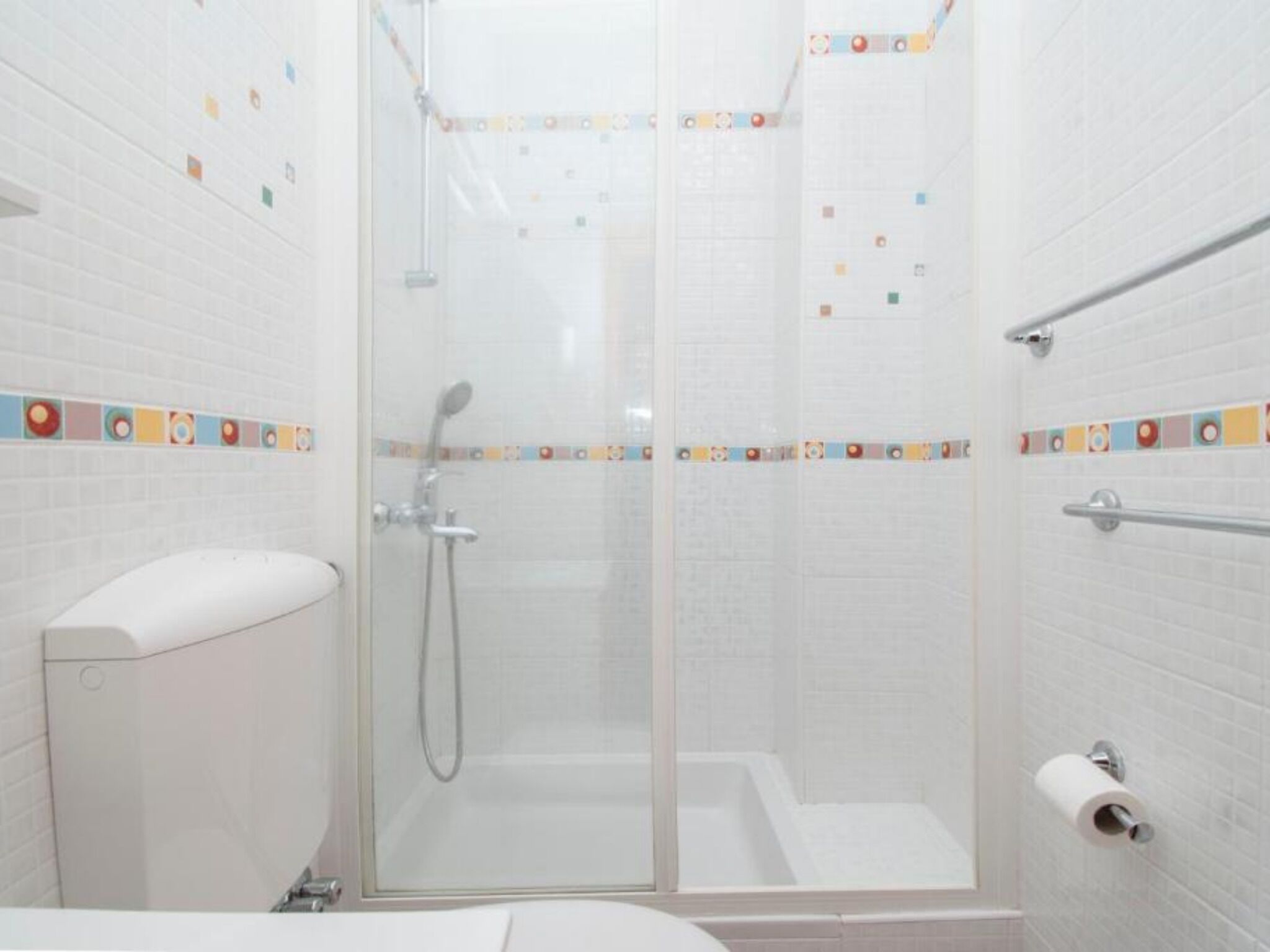 Un baño con cabina de ducha de vidrio, inodoro y bañera.