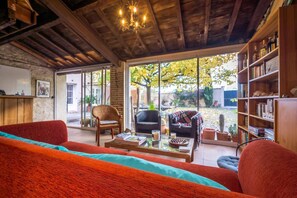 Una sala de estar acogedora con un sofá rojo, una mesita de centro y una estantería.
