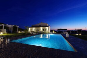 Una piscina con una casa al fondo.