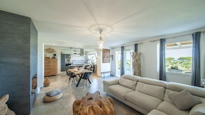 Un salon moderne comprenant un canapé, une table basse en bois et un coin repas avec une table et des chaises.