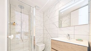 A modern bathroom with a glass-enclosed shower, a toilet, and a vanity with a mirror. - Viva Riviera Studio 5 Rue Florian (Cannes)