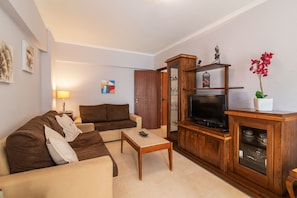 Ein Wohnzimmer mit Sofa, Couchtisch, TV-Möbel und Dekorationselementen.