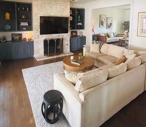 Un salon avec un canapé, une table basse, une cheminée et un téléviseur.