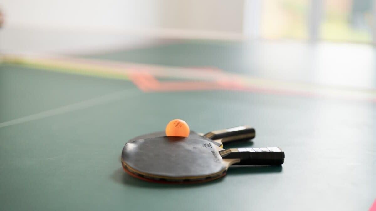 Une table de ping-pong avec une raquette et une balle.