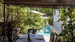 A covered outdoor dining area with a pool in the background. - Rn-c357-dpre31at - Villa Corona 8 (Cattolica)