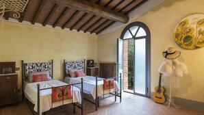 A bedroom with two beds, a guitar, a hat, and a sunflowers painting. - Ar-d649-foch0ar - Villa Joy 8 (Foiano della Chiana)