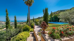 A landscaped garden with a stone pathway, a decorative urn, and a pool. - Ap-a047-cfpe10at - Fontespina 6 (Acquaviva Picena)