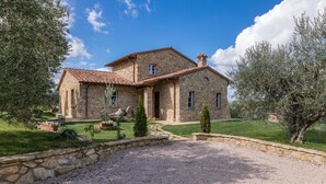 A stone house with a tiled roof, a central entrance, and a gravel driveway. - Pg-c744-cipi0at - La Villetta di Dante 6 (Citta della Pieve)