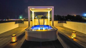 A rooftop hot tub with a modern design, surrounded by wooden flooring and decorative candles. - Rn-f244-onel10at - Portoverde Beach Villa 12 (Misano Adriatico)