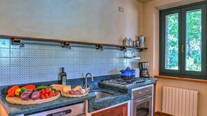 Enjoy cooking in this well-equipped kitchen with a gas stove, oven, and ample utensils.