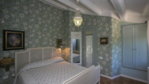 A bedroom with floral wallpaper, a bed with a canopy, a chandelier, and a wardrobe. - Fm-l279-tspa0at - Il Podere di Fi 8 (Torre San Patrizio)