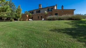 A two-story building with a flat roof, a brick facade, and a grassy lawn in front.